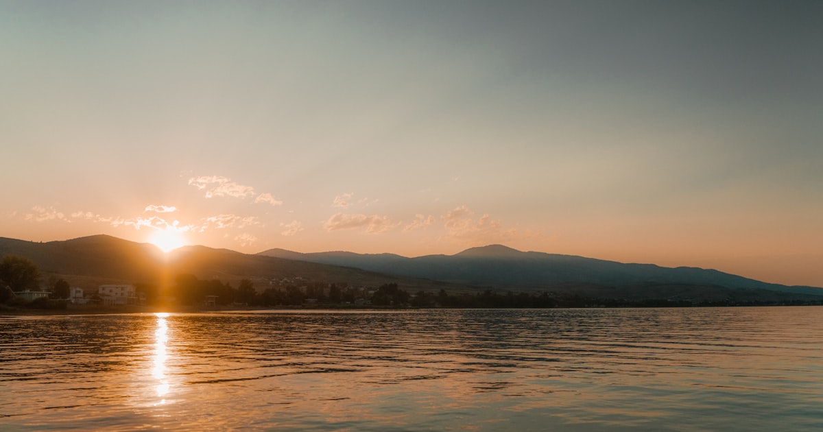 Nascer do sol sobre um lago calmo e montanhas, imagem que evoca o estado de segurança do sistema nervoso ventral vagal